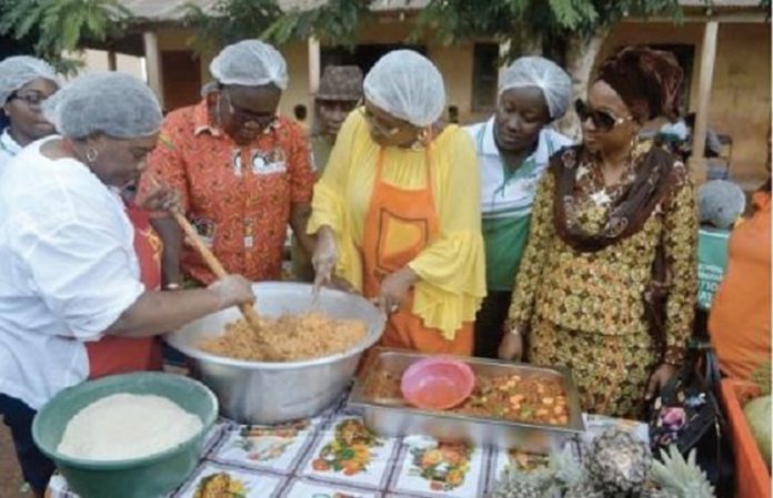 Cynthia Morrison being assisted by Dr Mrs Gertrude Quashigah to prepare the 'gari fotor Cynthia Morrison being assisted by Dr Mrs Gertrude Quashigah to prepare the 'gari fotor