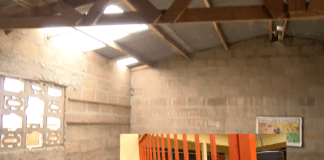 Ripped off roof of the school. Insert: the new school building under lock