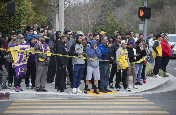 People gather on Las Virgenes Road in Calabasas near the scene of Sunday’s helicopter crash.(Mel Melcon / Los Angeles Times) People gather on Las Virgenes Road in Calabasas near the scene of Sunday’s helicopter crash.(Mel Melcon / Los Angeles Times)