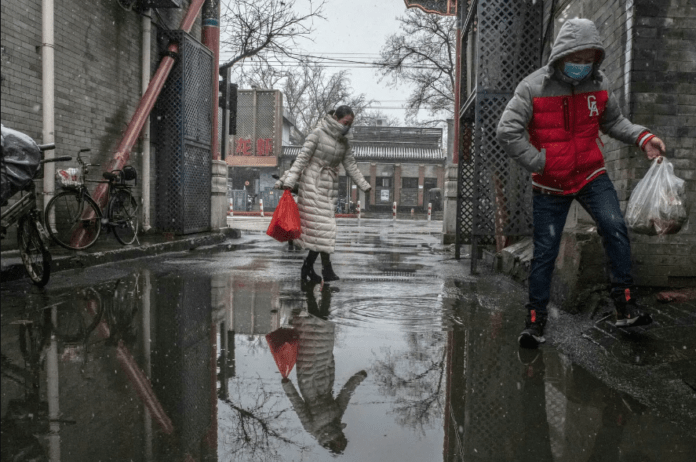 Returning from shopping in Beijing. The Chinese authorities reported 1,886 new confirmed cases on Tuesday, the first time since Jan. 30 that the number has been below 2,000.Credit...Gilles Sabrié for The New York Times