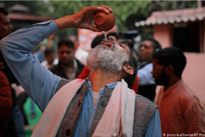 image-258 A group of Indians holding a cow urine drinking party