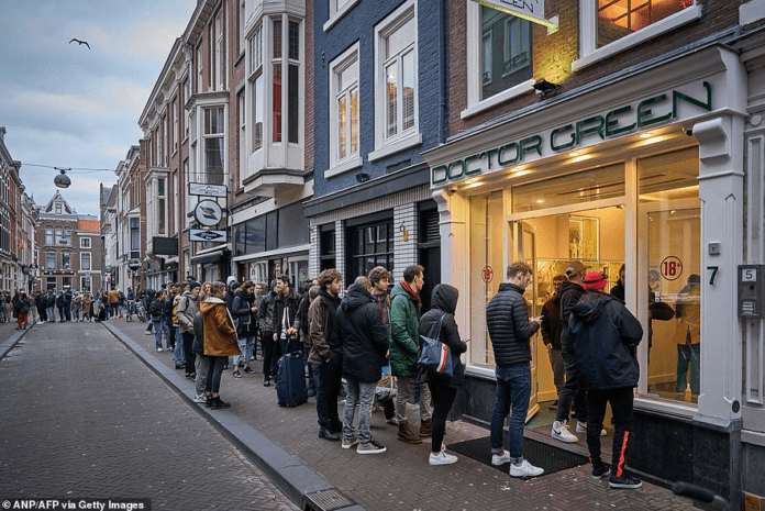 image-286 A queue of people line up outside a shop called Doctor Green - one of Holland's famous 'coffee shops' - in the Hague yesterday after the Dutch government announced that many businesses were closing over coronavirus fears