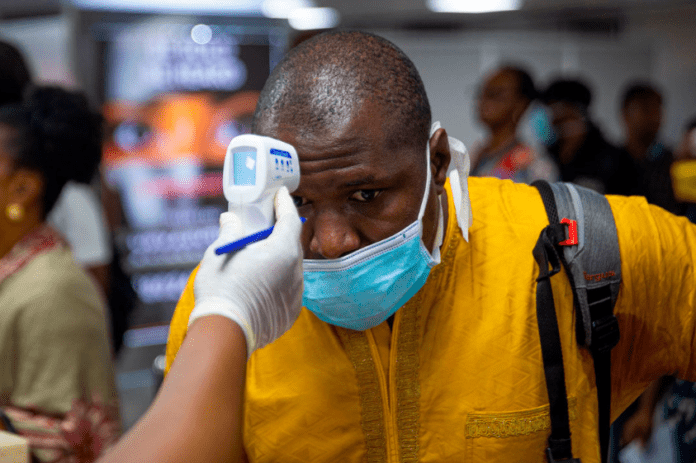 covid-19 Man being checked with a gun thermometer at a checkpoint because of Coronavirus