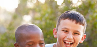 A black boy laughing with a white boy