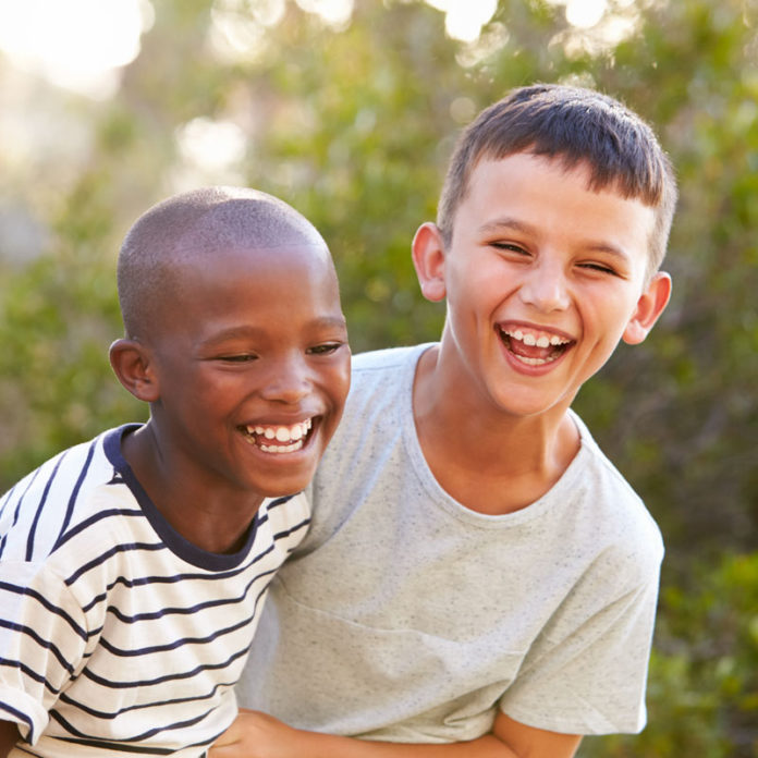 A black boy laughing with a white boy A black boy laughing with a white boy
