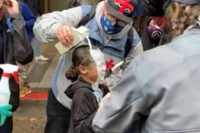 One man poured milk over the girl's head after she was allegedly pepper-sprayed by police (Image: evanmichael/Instagram) One man poured milk over the girl's head after she was allegedly pepper-sprayed by police (Image: evanmichael/Instagram)