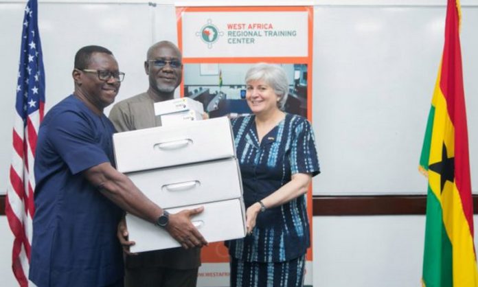 This screenshot from the U.S. Embassy in Ghana website shows Ambassador Stephanie Sullivan, right, donating technology to the executive director of the Economic and Organized Crime Office, Frank Adu-Poku, rear, and Jacob Puplampu, left, at a “cyber dark web investigations training” session in Accra in May 2019. This screenshot from the U.S. Embassy in Ghana website shows Ambassador Stephanie Sullivan, right, donating technology to the executive director of the Economic and Organized Crime Office, Frank Adu-Poku, rear, and Jacob Puplampu, left, at a “cyber dark web investigations training” session in Accra in May 2019.