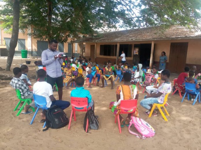 Volunteer teacher in Keta in the Volta Region, Hope-Nanegbe Enoch is reading to some learners as part of Right To Play's Covid-19 intervention in rural communities. Right To Play