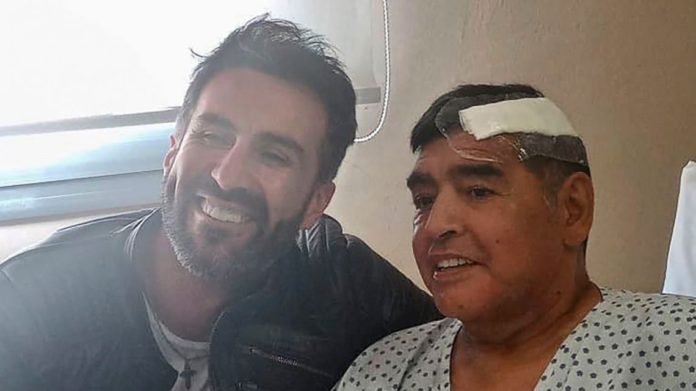 THIS HANDOUT PHOTO RELEASED BY THE PRESS OFFICER FOR DIEGO ARMANDO MARADONA SHOWS THE ARGENTINE FOOTBALL LEGEND SHAKING HANDS WITH HIS DOCTOR, LEOPOLDO LUQUE, AT THE OLIVOS CLINIC THIS HANDOUT PHOTO RELEASED BY THE PRESS OFFICER FOR DIEGO ARMANDO MARADONA SHOWS THE ARGENTINE FOOTBALL LEGEND SHAKING HANDS WITH HIS DOCTOR, LEOPOLDO LUQUE, AT THE OLIVOS CLINIC