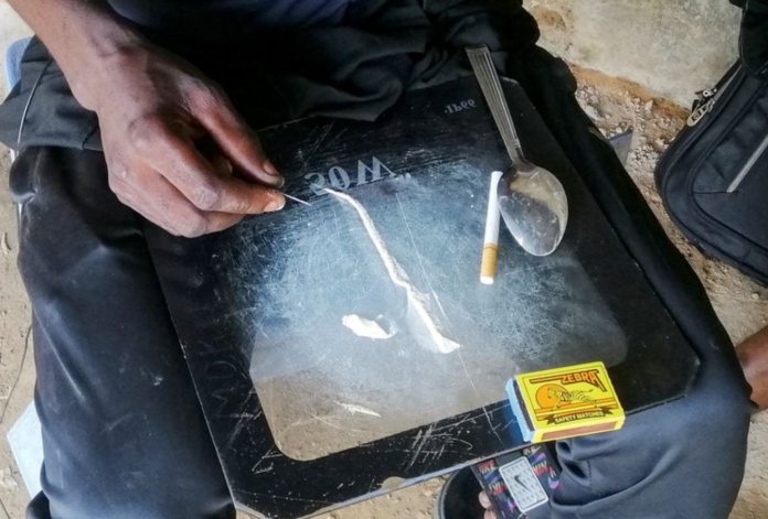 A man shows a substance known as "bombe", a mix of catalytic converters' crushed honeycomb and pills, before snorting it, in Kinshasa, Democratic Republic of the Congo August 31, 2021. Picture taken August 31, 2021. REUTERS/Benoit Nyemba