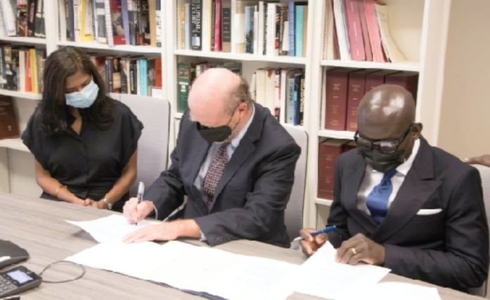 Mr. Godfred Yeboah Dame (right), the Attorney-General, and Professor William Treanor (middle), Dean of the Georgetown University Law Center signing the agreement in Washington DC, US