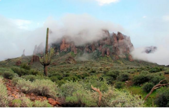 In this Jan. 29, 2015, file photo, low-hanging winter clouds hug part of Superstition Mountain in Lost Dutchman State Park in Apache Junction, Ariz. In this Jan. 29, 2015, file photo, low-hanging winter clouds hug part of Superstition Mountain in Lost Dutchman State Park in Apache Junction, Ariz.