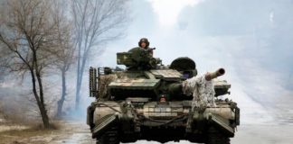 Ukrainian servicemen ride on tanks toward the front line with Russian forces in the Luhansk region of Ukraine on Friday. The president has waived entry visa requirements for any foreigners who want to join the fight against Russia. (Anatolii Stepanov/AFP via Getty Images)