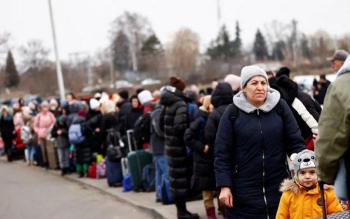 People wait to board a bus at the border checkpoint in Medyka after fleeing Ukraine - Reuters/Yara Nardi People wait to board a bus at the border checkpoint in Medyka after fleeing Ukraine - Reuters/Yara Nardi