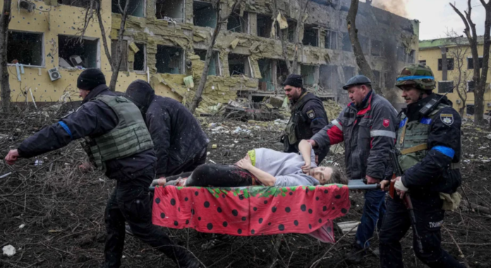 Ukrainian emergency employees and volunteers carry an injured pregnant woman from the damaged by shelling maternity hospital in Mariupol, Ukraine, March 9, 2022. - Copyright AP Photo/Evgeniy Maloletka