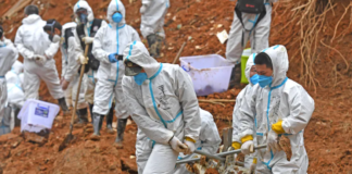 Rescuers carry a piece of plane wreckage at the site of the March 21 crash in southern China's Guangxi province. (Zhou Hua/AP)