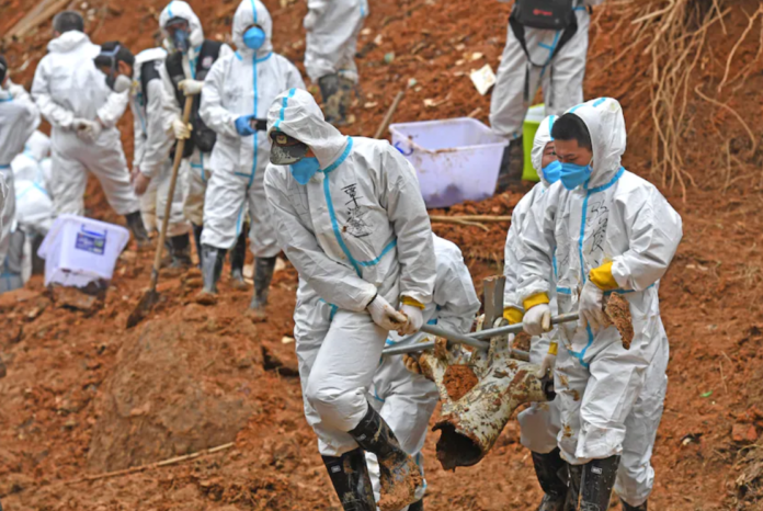 Rescuers carry a piece of plane wreckage at the site of the March 21 crash in southern China's Guangxi province. (Zhou Hua/AP) Rescuers carry a piece of plane wreckage at the site of the March 21 crash in southern China's Guangxi province. (Zhou Hua/AP)