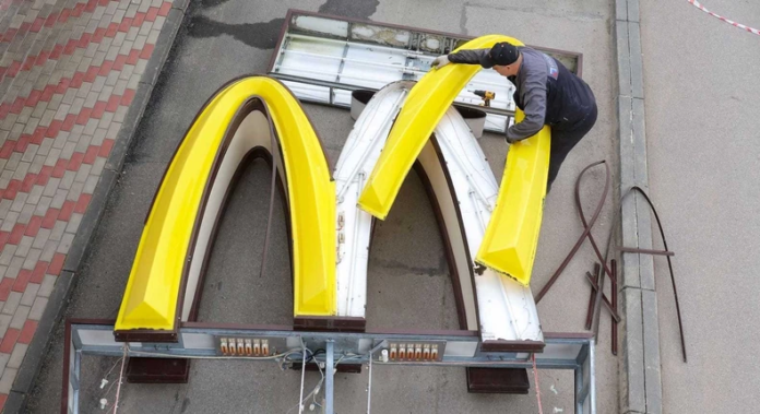 A worker dismantles the McDonald's Golden Arches logo at a drive-through restaurant in Kingisepp, Russia. A worker dismantles the McDonald's Golden Arches logo at a drive-through restaurant in Kingisepp, Russia.