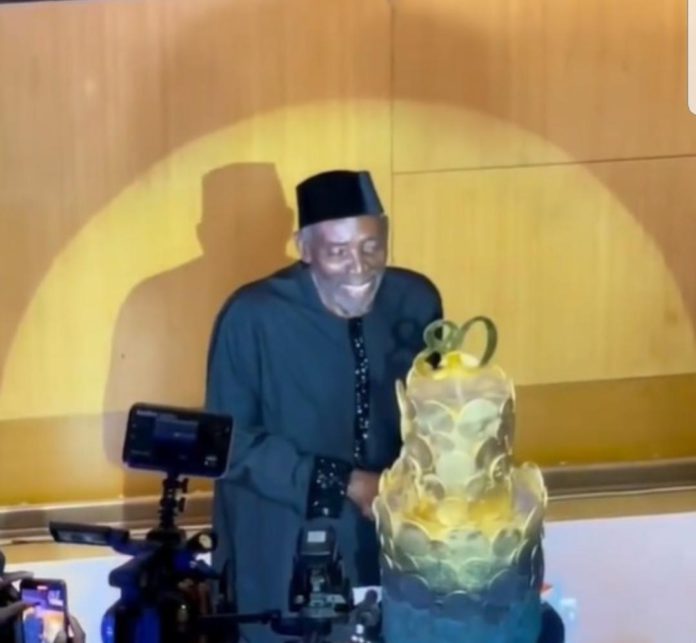 Olu Jacobs cutting 8oth birthday cake