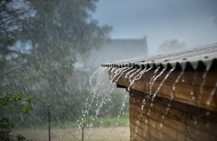 Rain flows down from a roof down
