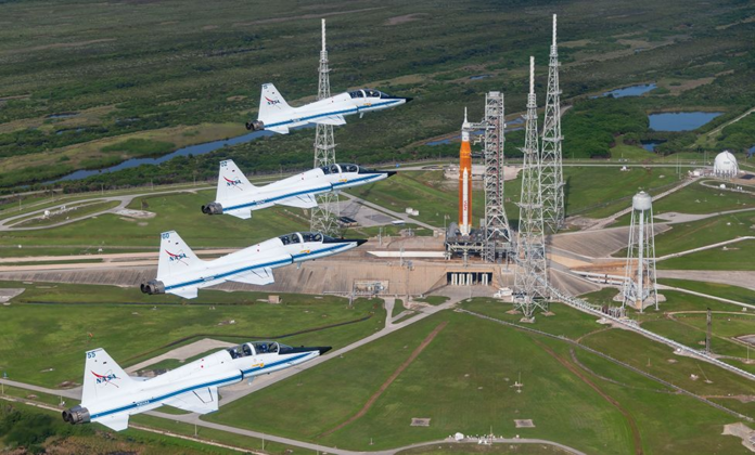 T-38 planes, a fixture of astronaut training at Nasa, fly over the SLS on launch pad 39B at Kennedy