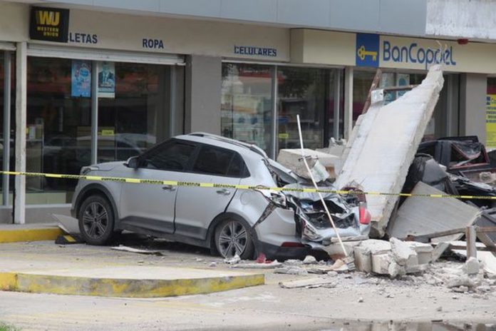 A vehicle smashed by the falling façade of a department store ( Image: REUTERS) A vehicle smashed by the falling façade of a department store ( Image: REUTERS)