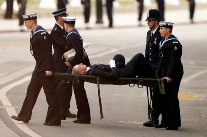 The police officer was stretchered away after collapsing ( Image: REUTERS) The police officer was stretchered away after collapsing ( Image: REUTERS)