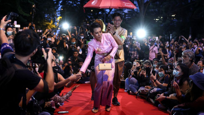 A Thai court ruled the activist - pictured in the pink dress - had mocked and defamed the Queen at this protest in 2020/ Reuters