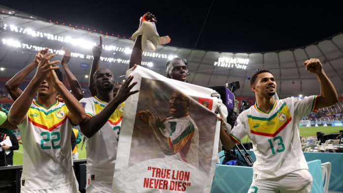 Senegal players applaud fans with a banner of Papa Bouba Diop, on the 2nd anniversary of his death, after their 2-1 victory in the FIFA World Cup Qatar 2022 Group A match between Ecuador and Senegal at Khalifa International Stadium on November 29, 2022 Image credit: Getty Images Senegal players applaud fans with a banner of Papa Bouba Diop, on the 2nd anniversary of his death, after their 2-1 victory in the FIFA World Cup Qatar 2022 Group A match between Ecuador and Senegal at Khalifa International Stadium on November 29, 2022 Image credit: Getty Images