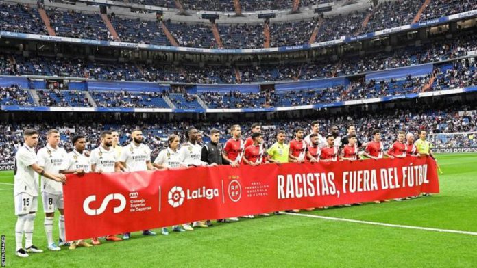 Real Madrid and Rayo Vallecano players held a banner saying "racists out of football" in support of Vinicius Jr before Wednesday's La Liga match at the Bernabeu Real Madrid and Rayo Vallecano players held a banner saying "racists out of football" in support of Vinicius Jr before Wednesday's La Liga match at the Bernabeu