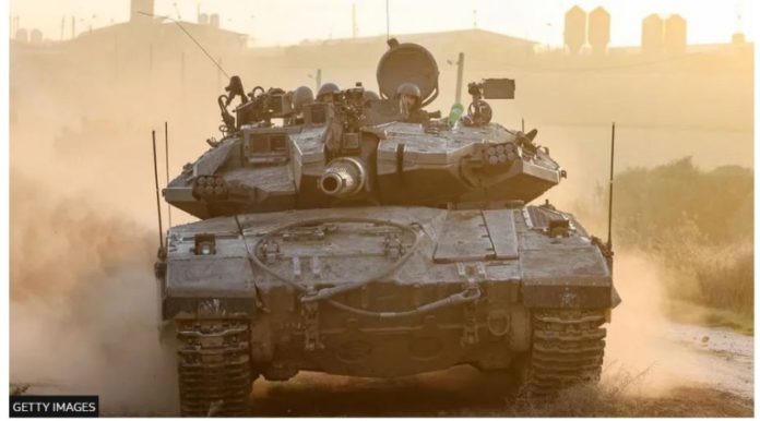 An Israeli military tank rolls near the border with the Gaza Strip on Sunday.