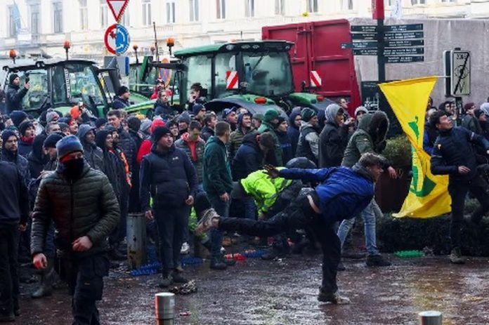 A person throws eggs towards the police officers as Belgian farmers use their tractors to block the European Union headquarters, as they protest over price pressures, taxes and green regulation, grievances shared by farmers across Europe, on the day of the EU summit in Brussels, Belgium February 1, 2024. REUTERS A person throws eggs towards the police officers as Belgian farmers use their tractors to block the European Union headquarters, as they protest over price pressures, taxes and green regulation, grievances shared by farmers across Europe, on the day of the EU summit in Brussels, Belgium February 1, 2024. REUTERS