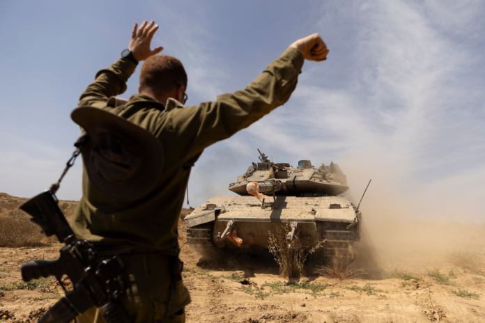 An Israeli soldier directed a tank near the border with the southern Gaza Strip on Thursday. AMIR LEVY/GETTY IMAGES An Israeli soldier directed a tank near the border with the southern Gaza Strip on Thursday. AMIR LEVY/GETTY IMAGES