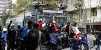 Demonstrators try to obstruct a police vehicle as police use water cannons to disperse protesters during a demonstration against Kenya's proposed finance bill 2024/2025 in Nairobi, Kenya, June 25, 2024. REUTERS/Monicah Mwangi