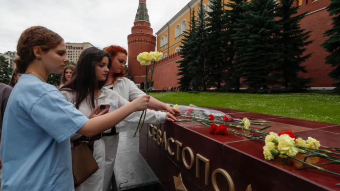 EPA/ People lay flowers as tribute to the victims of Sunday's attack on a memorial bearing the word Sevastopol in Moscow EPA/ People lay flowers as tribute to the victims of Sunday's attack on a memorial bearing the word Sevastopol in Moscow