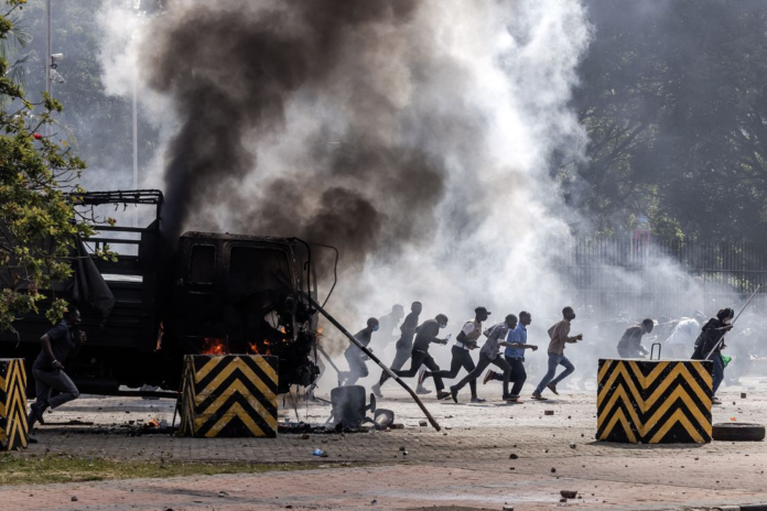 Protesters run to take cover outside the Kenyan Parliament after storming the building.Luis Tato/AFP/Getty Images