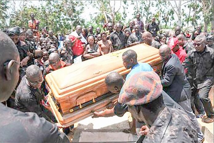 Pall bearers with a casket and mourners
