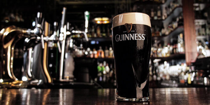 Zoom in on a glass of Guinness beer in a bar